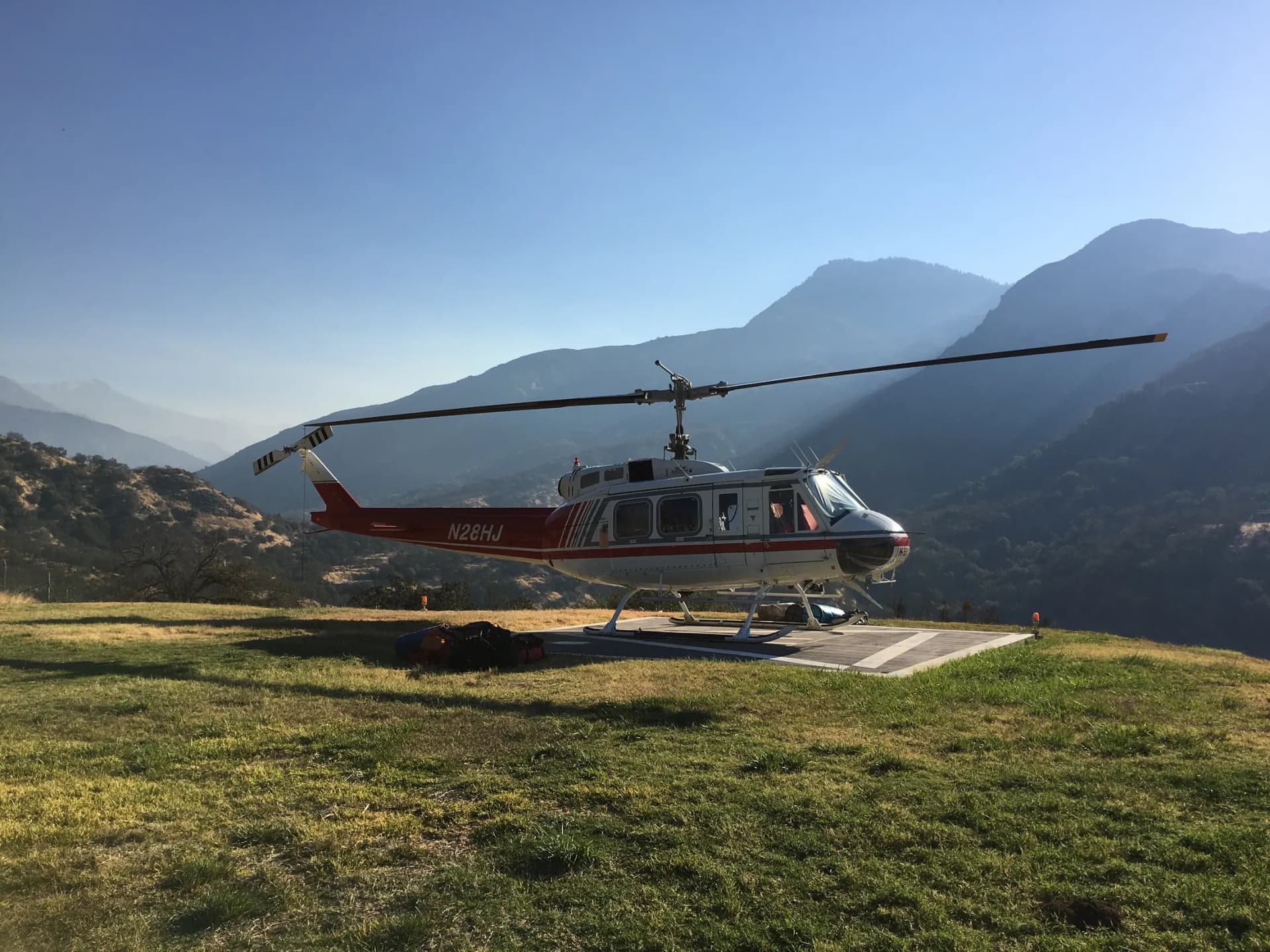 A Bell 205 parked on a mountain helipad