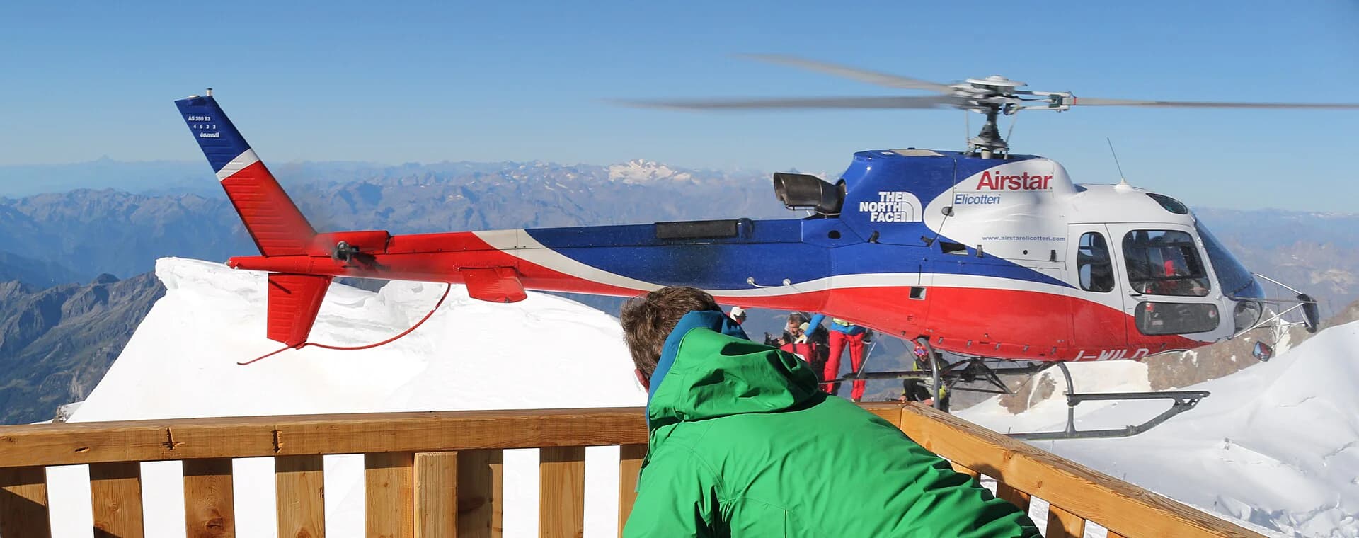 An AS350 B3 helicopter beside a high mountain hut in the Monte Rosa massif